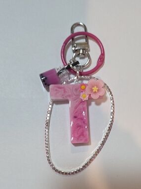 Pink Resin 'T' Keychain with Floral Accents, a Pink Krystal Bracelet & drink